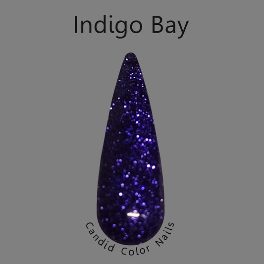 A finger nail swatch with a dark bluish purple extra fine metallic / reflective glitter in a clear dip powder base.